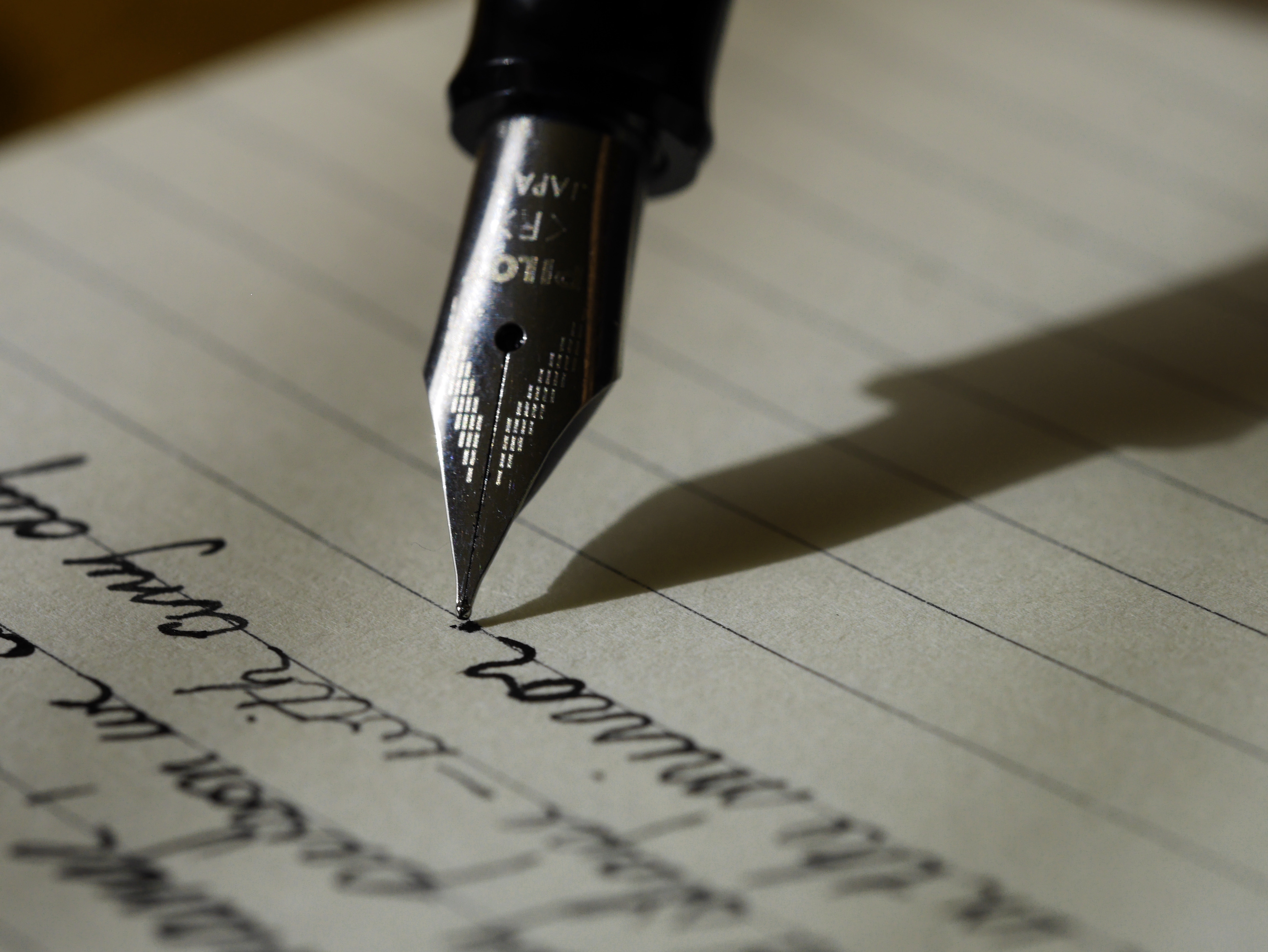 Close-up view of a pen writing on lined paper