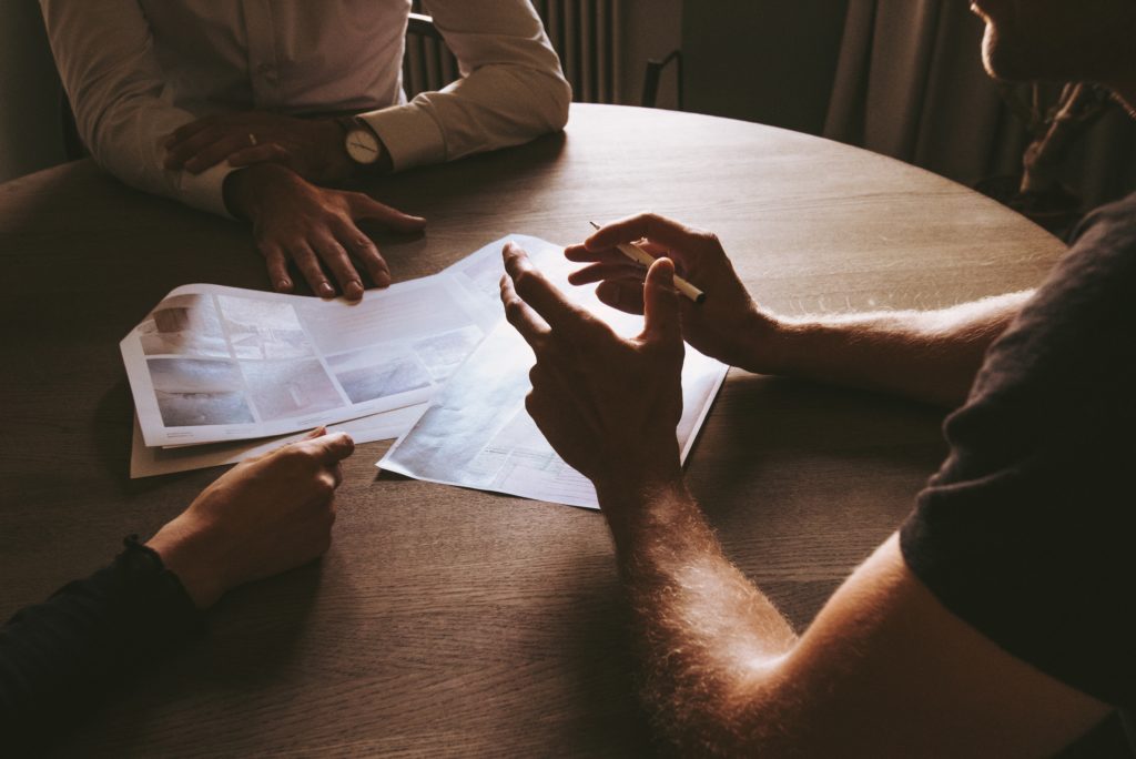 Hands of three people who are talking around a table