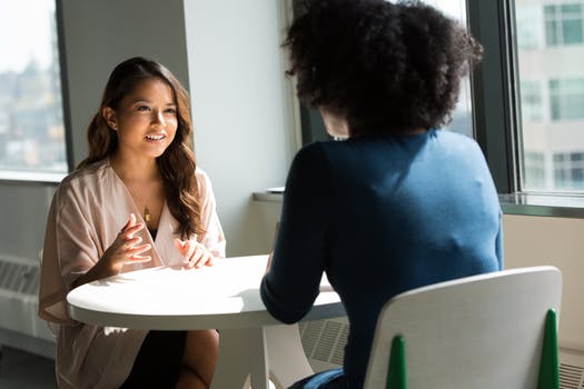 Two women sitting across from each other and talking